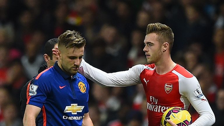 Calum Chambers of Arsenal gestures to Luke Shaw of Manchester United (L) as he walks off injured