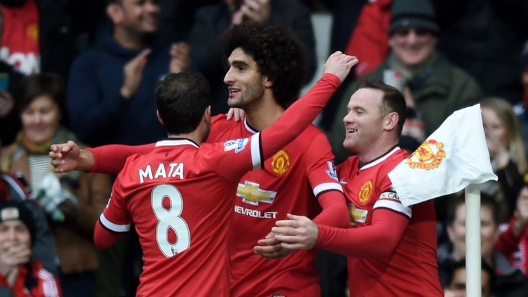 Marouane Fellaini (C) of Manchester United is congratulated by teammates Juan Mata (L) of Manchester United and Wayne Rooney