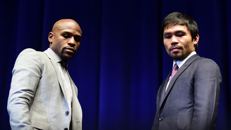Boxers Manny Pacquiao (R) from the Philippines and Floyd Mayweather from the US look down while posing during a press conference
