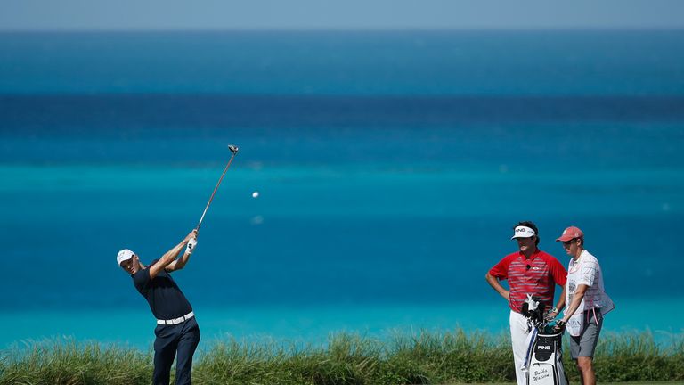 Martin Kaymer of Germany hits his tee shot on the ninth hole as Bubba Watson of the United States looks on. 