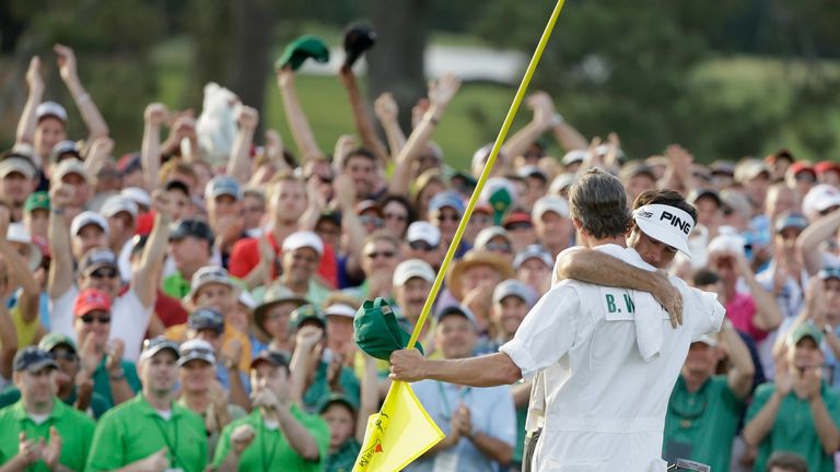 Bubba Watson of the United States hugs his caddie Ted Scott on the 18th green after winning the 2014 Masters Tournament.
