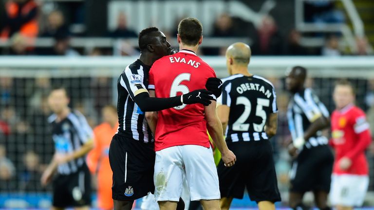 Manchester United player Jonny Evans (r) looks on as Papiss Cisse of Newcastle appears to spit 