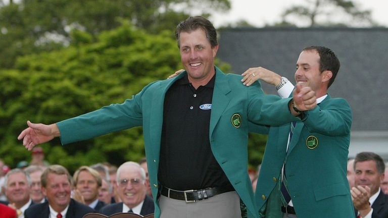 Phil Mickelson is presented the green jacket by 2003 Masters champion Mike Weir of Canada after the final round of the Masters .