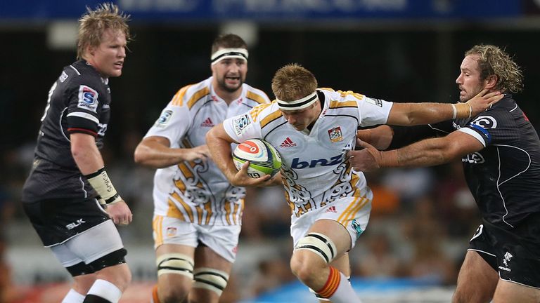  Sam Cane of the Chiefs hands off  Jannie du Plessis of the Cell C Sharks during the Super Rugby match
