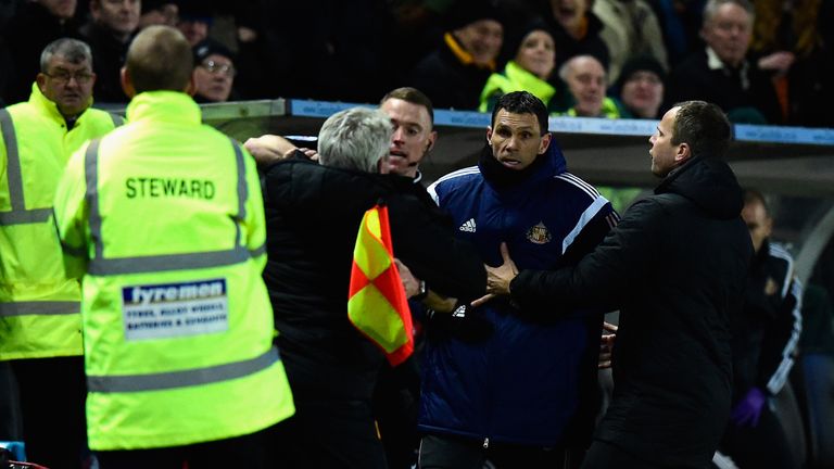 HULL, ENGLAND - MARCH 03:  Hull manager Steve Bruce is held back by the assistant referee as he and Sunderland manager Gus Poyet argue after Poyet is sent 