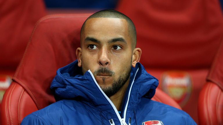 Theo Walcott of Arsenal looks on from the substitutes bench during the Champions League round of 16 match between Arsenal and Monaco at The Emirates