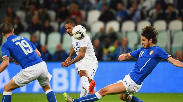 Theo Walcott shoots under pressure from Andrea Ranocchia of Italy 