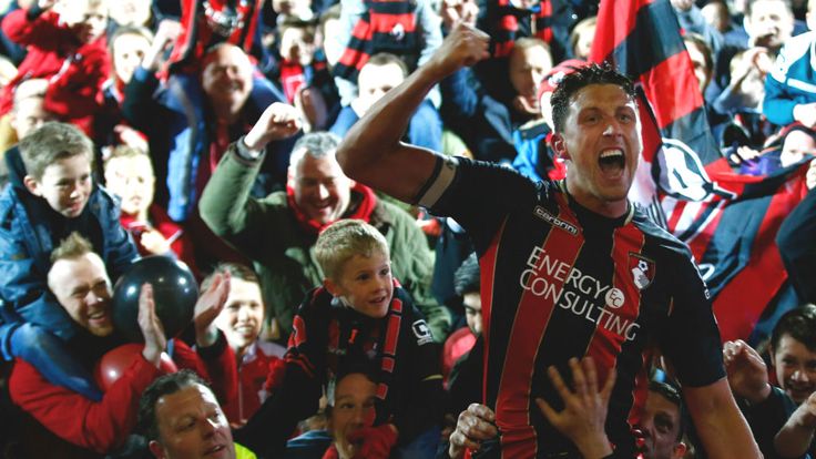 Captain Tommy Elphick of Bournemouth celebrates victory as fans invade the pitch at Goldsands Stadium