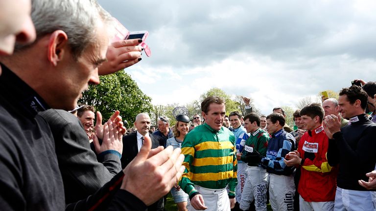 ESHER, ENGLAND - APRIL 25: Jockeys greet Tony McCoy into the parade ring on the day he retires from the saddle at Sandown racecourse on April 25, 2015 in E