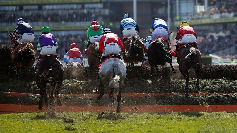 A general view as runners clear a fence at Aintree