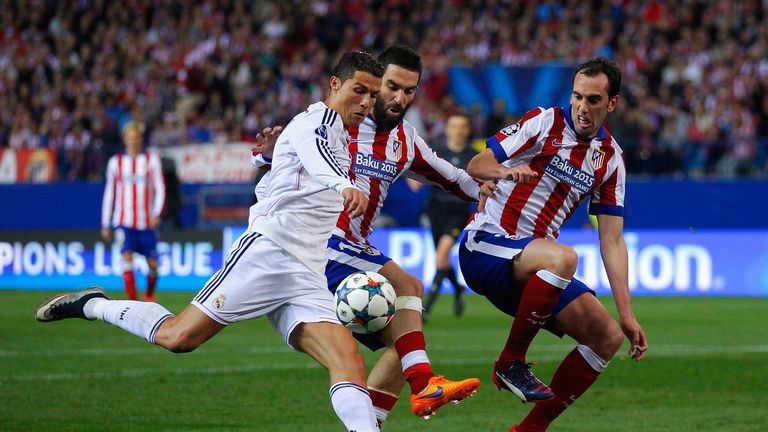 Cristiano Ronaldo of Real Madrid CF is closed down by Arda Turan  and Diego GodÃin of Atletico Madrid