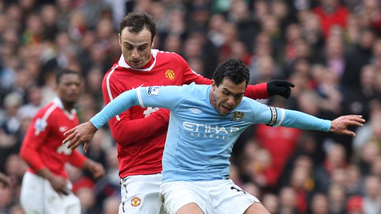 Dimitar Berbatov of Manchester United and Carlos Tevez of Manchester City compete for the ball at Old Trafford on February 12, 2011 in Manchester, England.