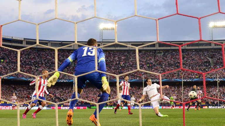 Gareth Bale (R) kicks a ball against Atletico Madrid's Slovenian goalkeeper Jan Oblakng the UEFA Champions League quarter final first leg football match
