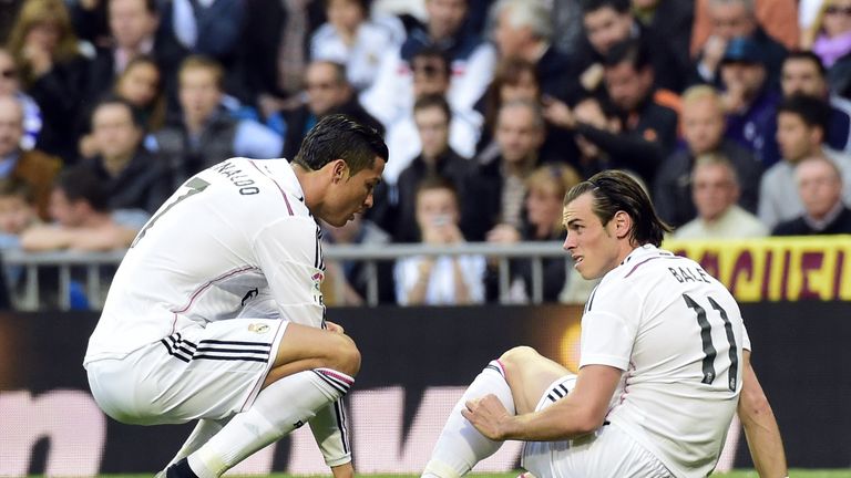 Gareth Bale (R) sits on the ground after being injured talking with Real Madrid's Portuguese forward Cristiano Ronaldo against Malaga