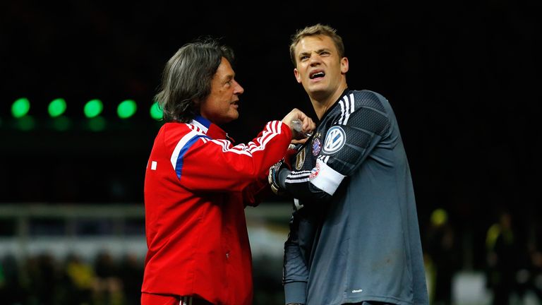 Manuel Neuer is treated by team doctor Hans-Wilhelm Mueller-Wohlfahrt after picking up a shoulder injury during the DFB Cup Final match against Dortmund