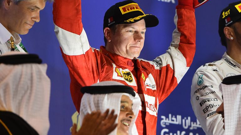Kimi Raikkonen celebrates with his trophy on the podium after finishing second in Bahrain