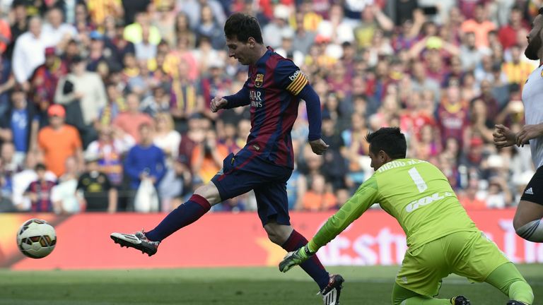 Lionel Messi (L) scores a goal