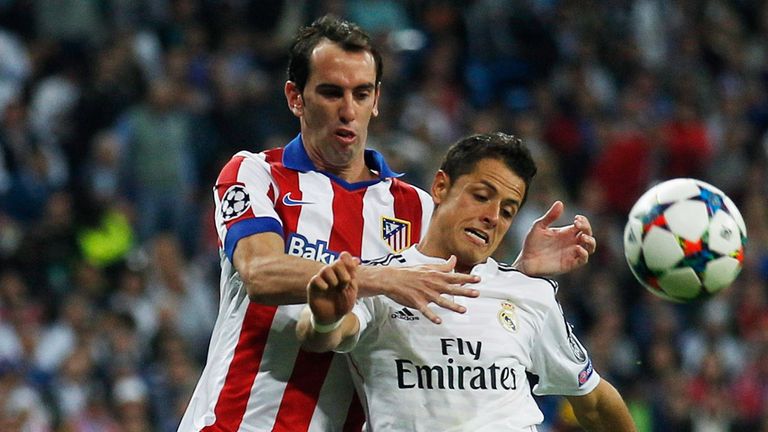 Diego Godin and Javier Hernandez compete for the ball