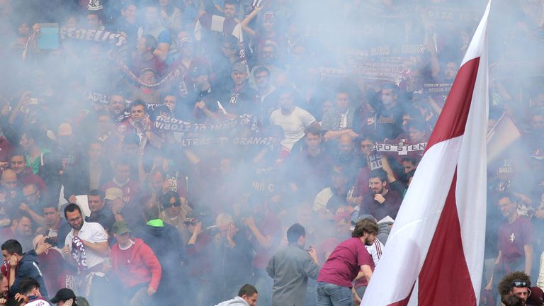 Torino fans react after a firework explodes during the Turin derby