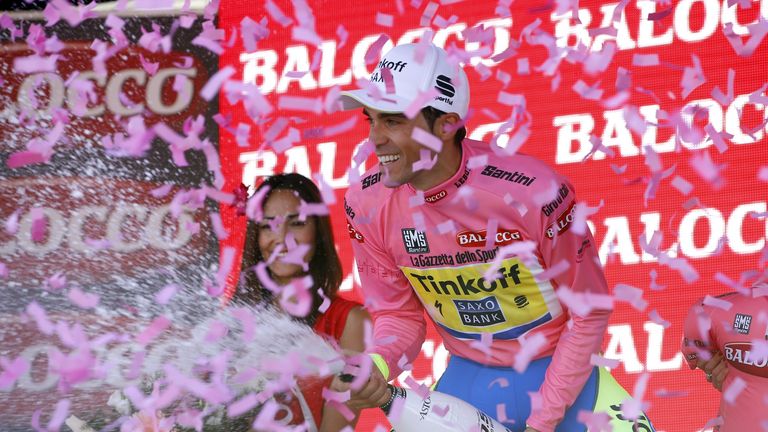 Spanish cyclist Alberto Contador celebrates champagne on the podium in his leader's pink jersey after the 17th stage of the 98th Giro d'Italia