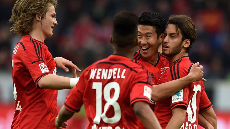 Leverkusen's midfielder Hakan Calhanoglu (R) celebrates scoring with his team-mates during the German first 