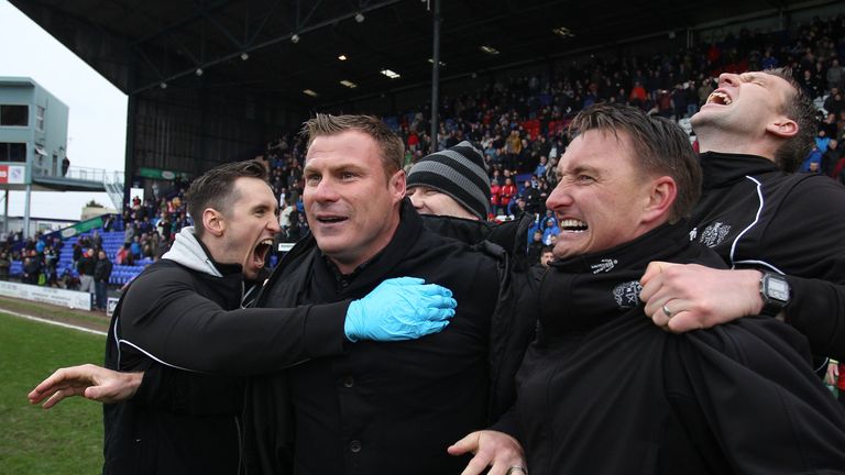 Bury's manager David Flitcroft (centre) celebrates with team staff after the final whistle is blown after securing their promotion to League One