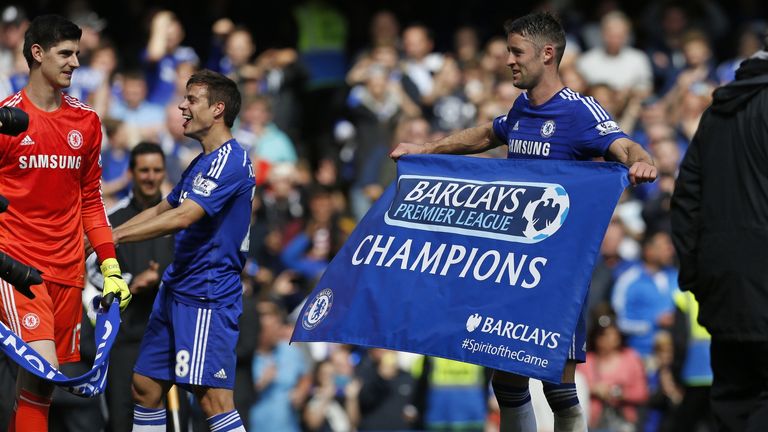 Chelsea's Gary Cahill (R) holds a 'champions' flag after the  match between against Crystal Palace at Stamford Bridge