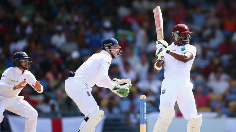 Darren Bravo hits out while wicketkeeper Jos Buttler looks on