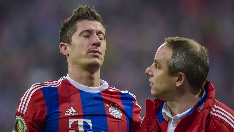 Bayern Munich's Polish striker Robert Lewandowski (L) speaks with Bayern Munich's team doctor Volker Braun