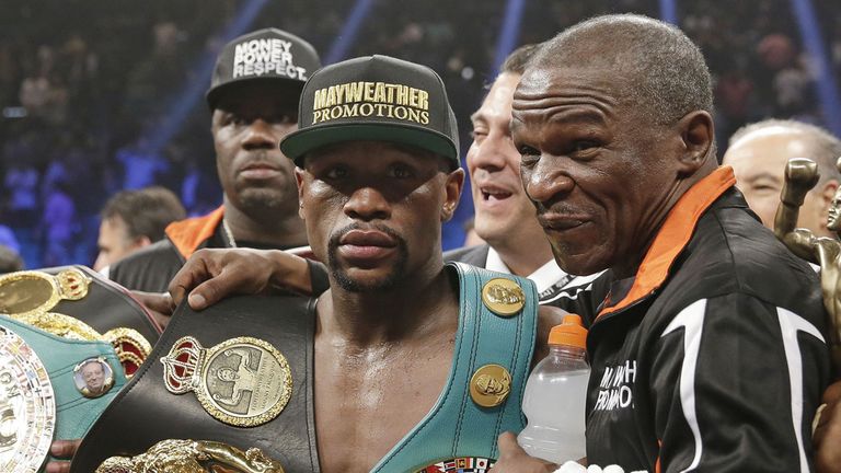 Floyd Mayweather Jr., left, poses with his champion's belts and his father, head trainer Floyd Mayweather Sr., after his victory over Manny Pacquiao