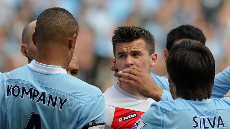 Queens Park Rangers' English midfielder Joey Barton (C) clases with Manchester City's captain Vincent Kompany (L) after being sent off by referee Mike Dean