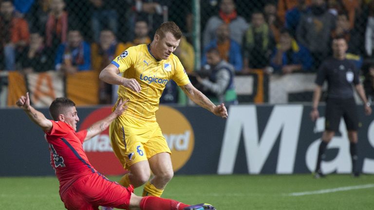 Paris Saint-Germain's midfielder Marco Verratti (L) tackles Apoel FCs defender John Arne Riise (R) during their UEFA Champions League match in 2014