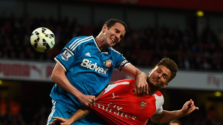 John O'Shea of Sunderland and Olivier Giroud of Arsenal tussle for the ball