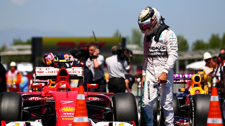 Lewis Hamilton looks at Kimi Raikkonen's Ferrari