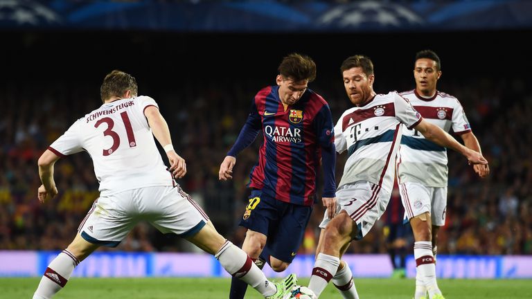 Lionel Messi of Barcelona is challenged by Bastian Schweinsteiger and Xabi Alonso of Bayern Muenchen 