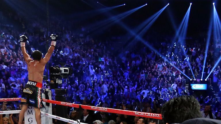 LAS VEGAS, NV - DECEMBER 08:  Manny Pacquiao lays face down on the mat after being knocked out in the sixth round as Juan Manuel Marquez celebrates during 