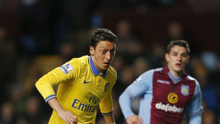 Arsenal's Mesut Ozil in Premier League action with Aston Villa's Ashley Westwood in pursuit at Villa Park in January 2014