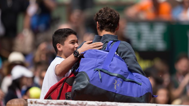 Young fan walk on court for a selfie with Roger Federer at Roland Garros