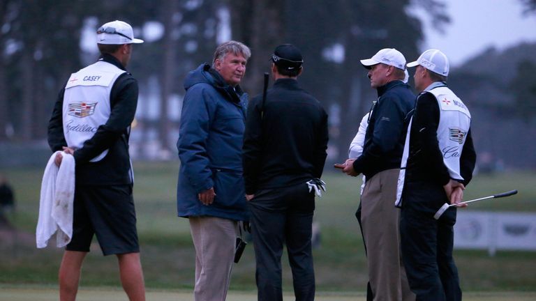 The match referee moves in to talk to Rory McIlroy of Northern Ireland and Paul Casey of England on the 16th green.