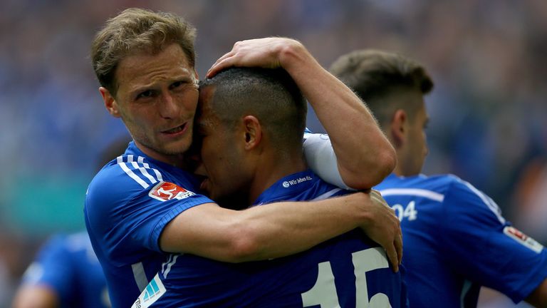 GELSENKIRCHEN, GERMANY - MAY 02: (L-R) Benedikt Hoewedes  embraces Dennis Aogo of Schalke after scoring the third goal during the Bundesliga match 