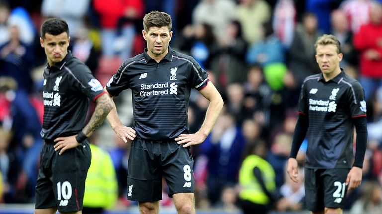 Philippe Coutinho (L), Steven Gerrard and Lucas Leiva (R) wait to kick off