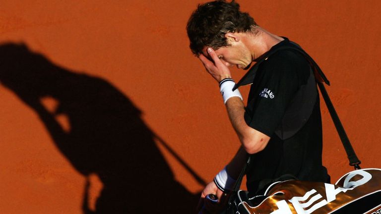 Andy Murray walks off court past Fernando Gonzalez following his defeat at the French Open in 2009