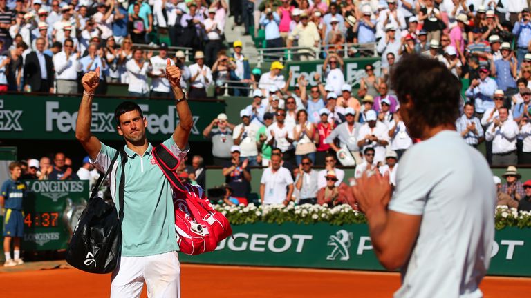 Novak Djokovic of Serbia applauds the fans as he walks off court applauded by Rafael Nadal of Spain after their men's singles sem