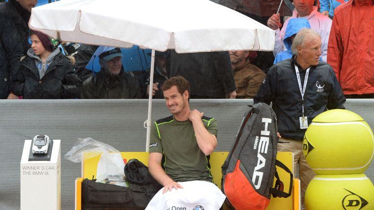 Andy Murray waits under an umbrella at the center court in Munich