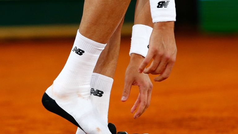 Milos Raonic  adjusts his shoes in his match against Andy Murray in the quarter-final at the Mutua Madrid Open