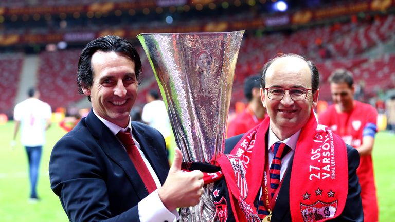 Unai Emery (L), coach of Sevilla poses with Sevilla President Jose Castro and the trophy after the UEFA Europa League Final match