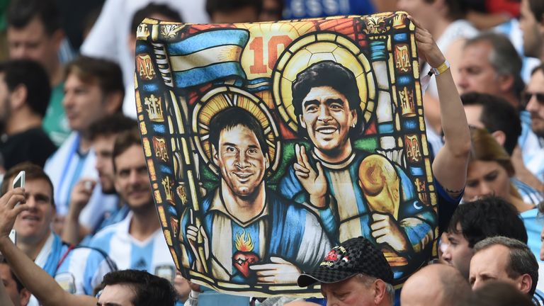 Argentina fan holds an image of Lionel Messi and Diego Maradona match against Nigeria at the Beira-Rio Stadium in Porto Alegre during the 2014 World Cup