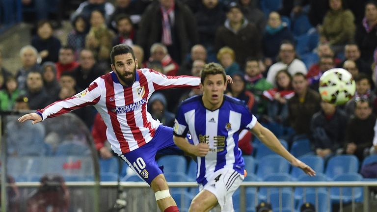 Atletico Madrid'smidfielder Arda Turan (L) kicks the ball