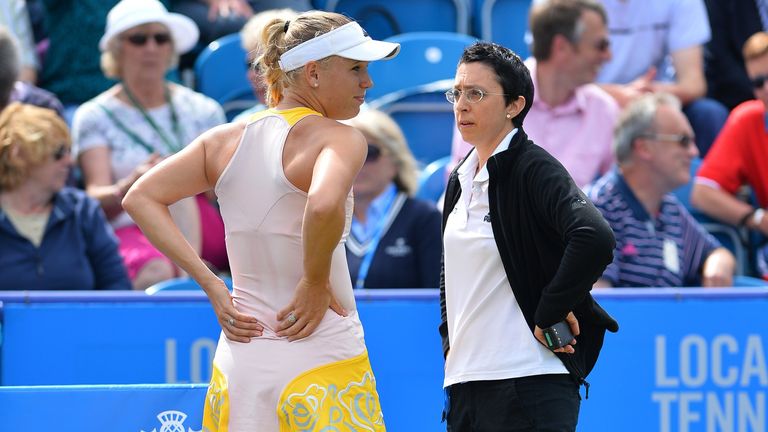 Caroline Wozniacki holds her back before withdrawing from her women's semi-final match against Belinda Bencic at the WTA Eastbourne International