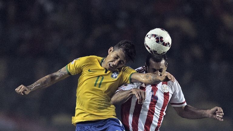Brazil's forward Roberto Firmino (L) and Paraguay's defender Paulo Da Silva